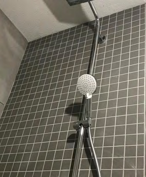 Graue Mosaikfliesen in einer Duschecke